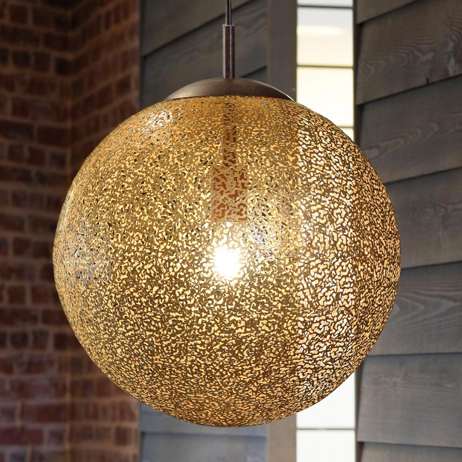 Close-up van de roestkleurige opengewerkte bol van de Greta hanglamp